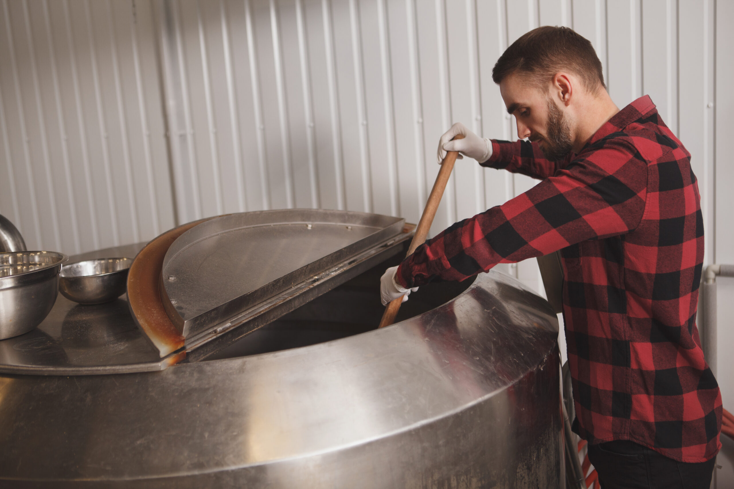 Brewer in a red flannel stirring.